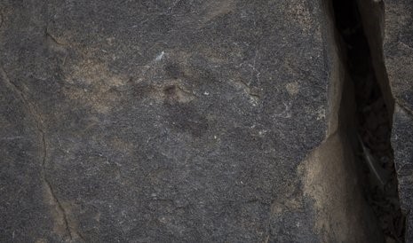 Photo: A bloody handprint stains a vertical rock surface (Greg Marinovich).